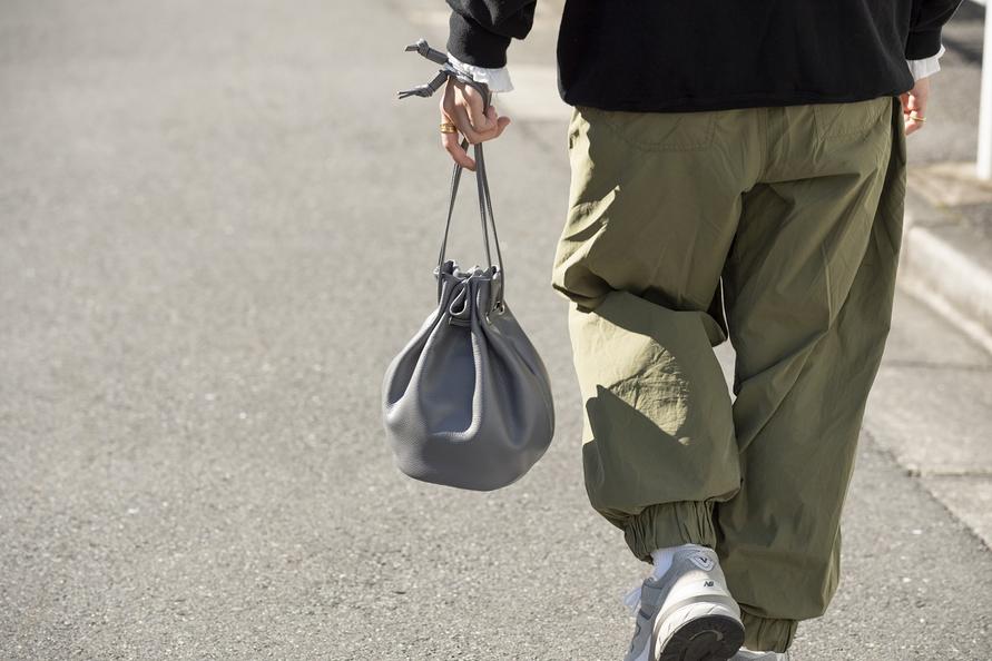 バッグを手で持つ　後ろ姿